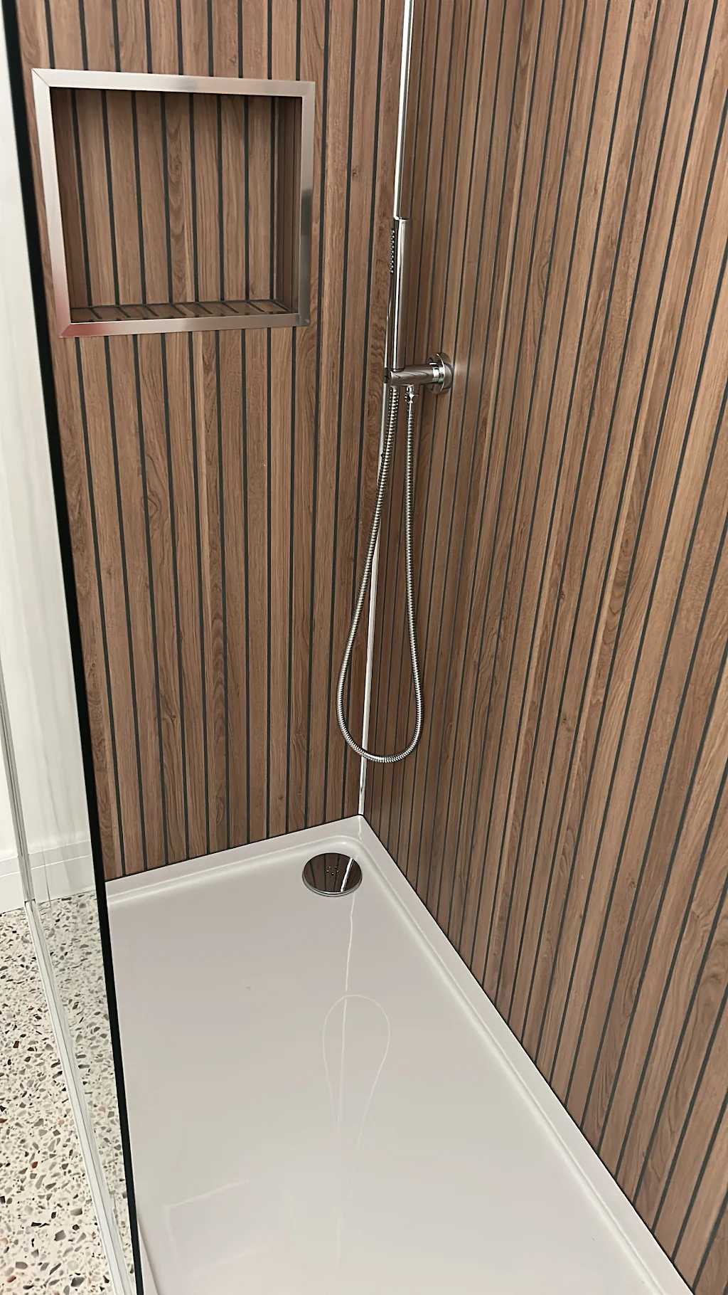 Modern bathroom shower enclosure with wood-grain wall panelling