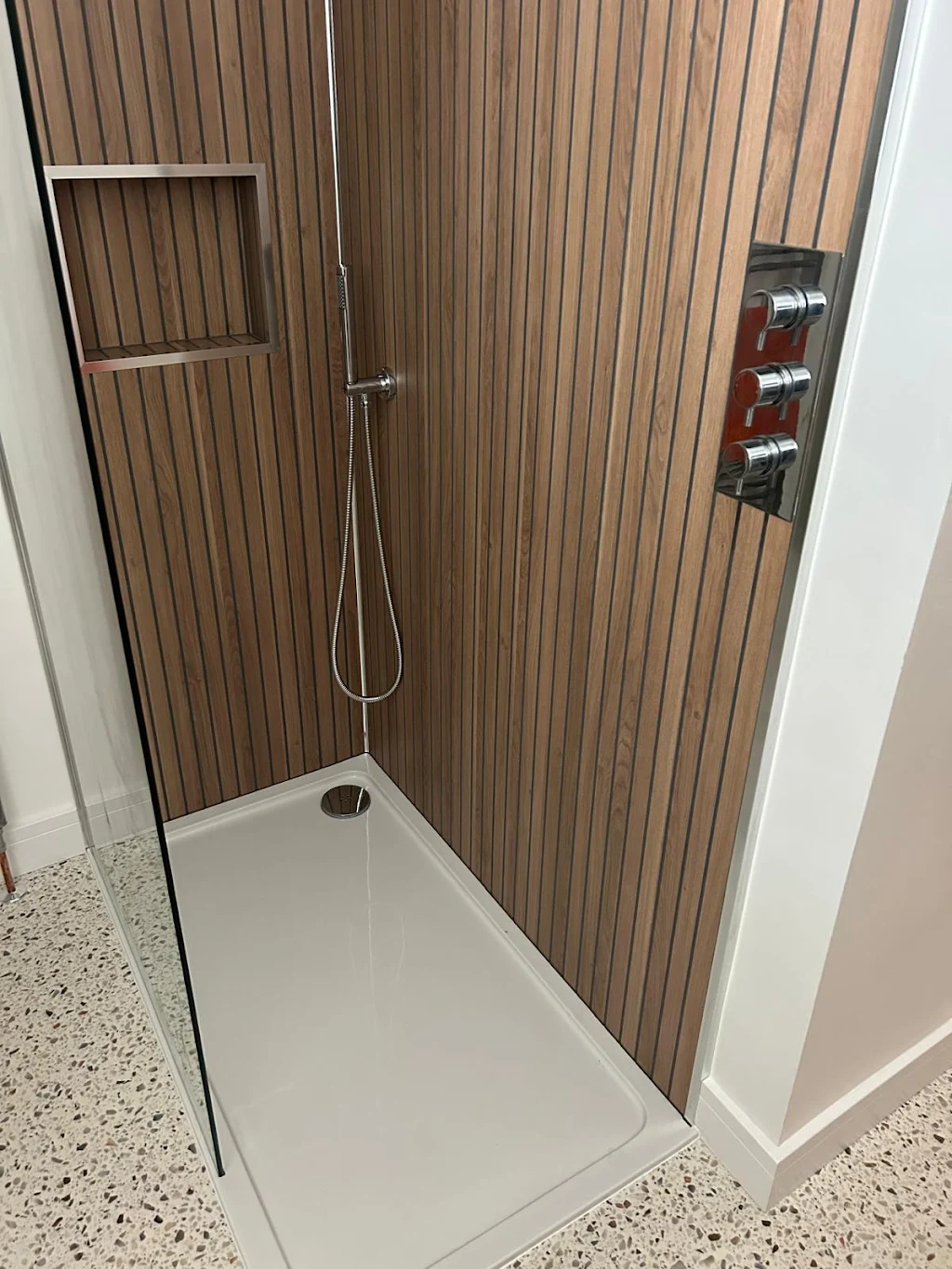 Modern walk-in shower with wood-effect wall panelling