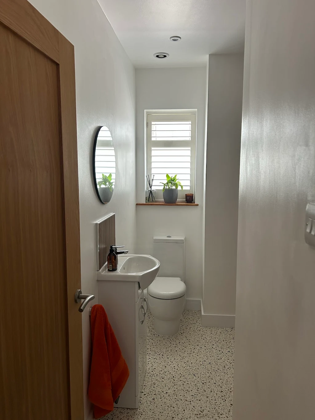 Modern finished bathroom with white walls and terrazzo flooring